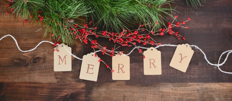 MERRY text cutout on white string by wreath